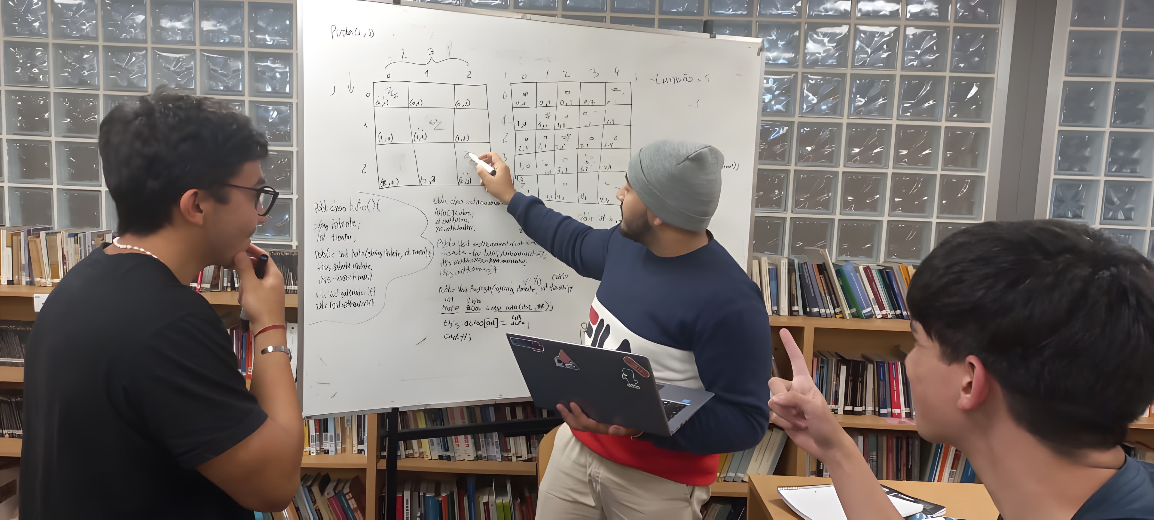 Alexis at a whiteboard, explaining a matrix exercise to two classmates in the university library